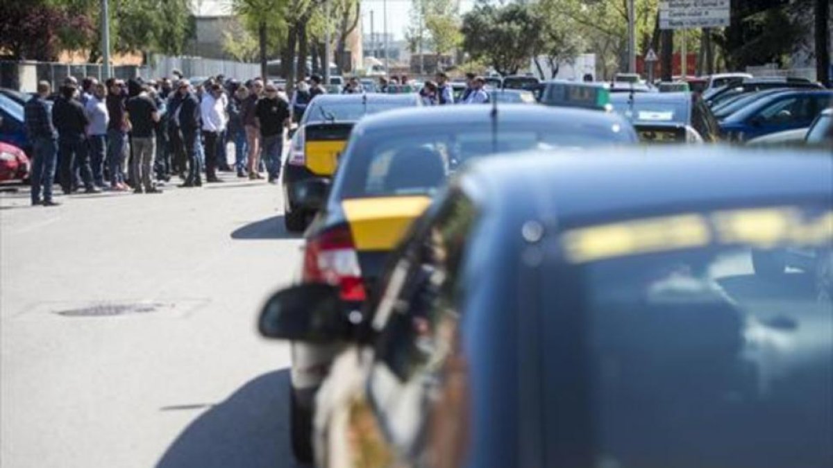 Protesta de taxistas ante la empresa de alquiler de vehículos con conductor Cabify en la Zona Franca, ayer.-JORDI COTRINA