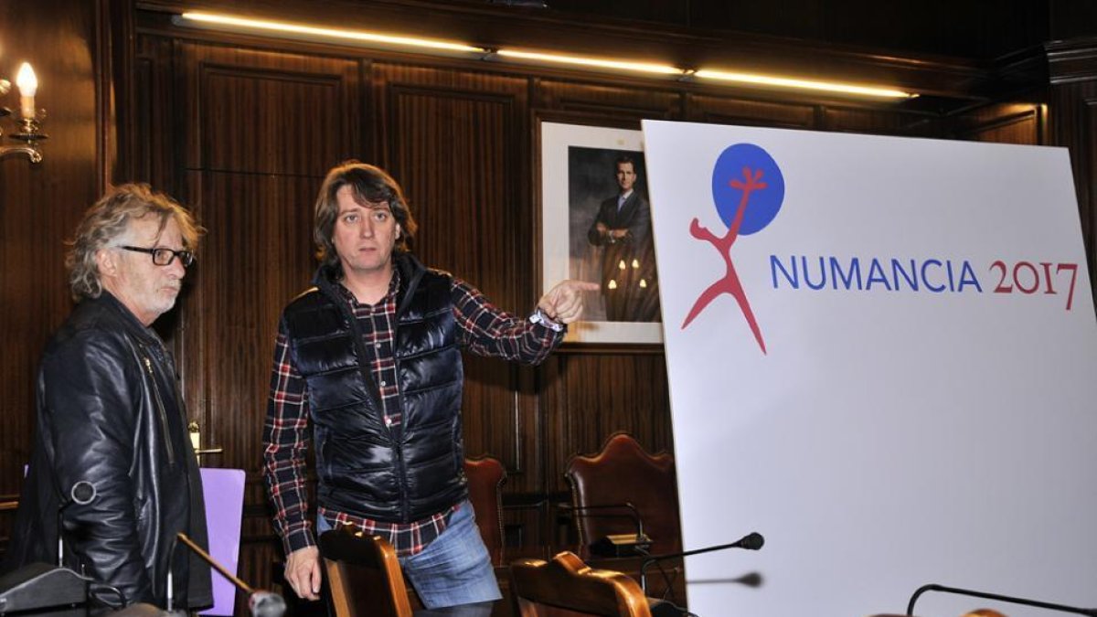 Carlos Martínez Mínguez y Javier Mariscal se saludan ante el logotipo.-VALENTÍN GUISANDE