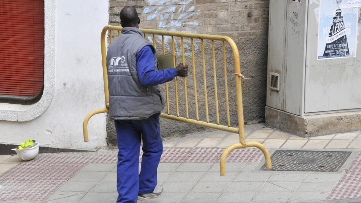 Un trabajador mueve una valla de obra.-VALENTÍN GUISANDE