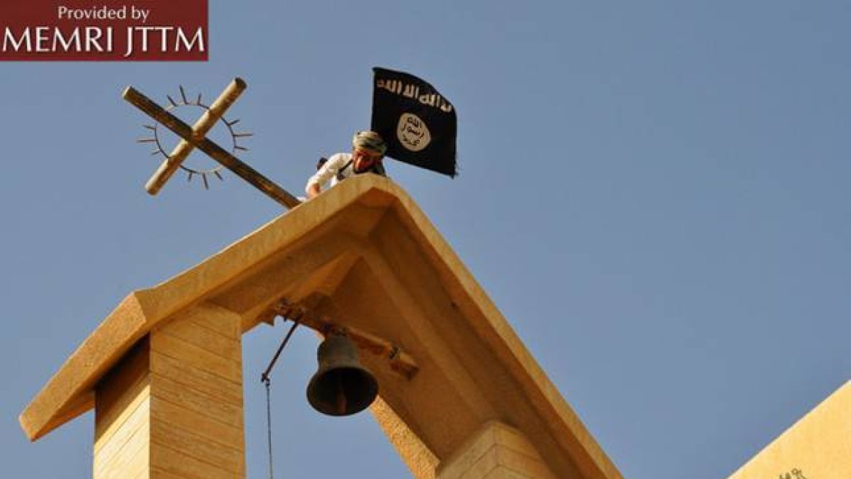 Terroristas del Estado Islámico colocan su bandera en una iglesia cristiana en el norte de Irak.-