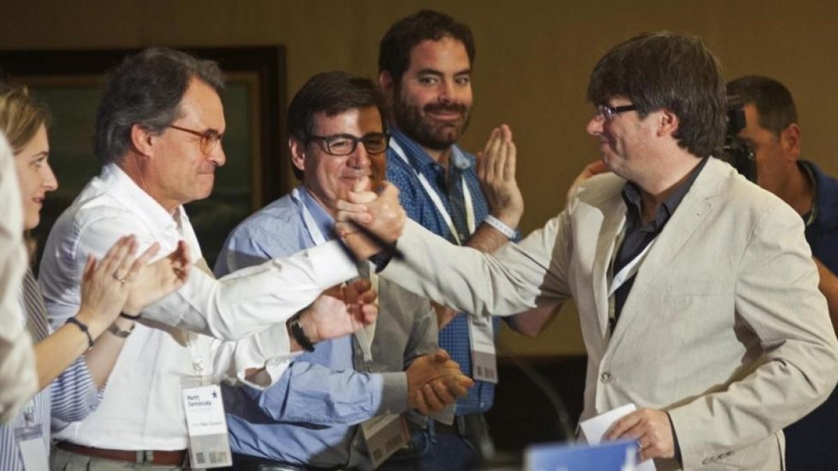 El presidente de la Generalitat, Carles Puigdemont (derecha) saluda al 'expresident' Artur Mas en el acto de Lloret de Mar.-Robin Townsend