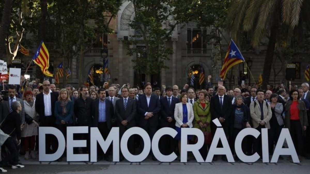 Carme Forcadell, junto a Carles Puigdemont y Artur Mas entre otros representantes políticos, en el passeig Lluís Companys junto a las letras de la palabra Democracia.-ALBERT BERTRAN