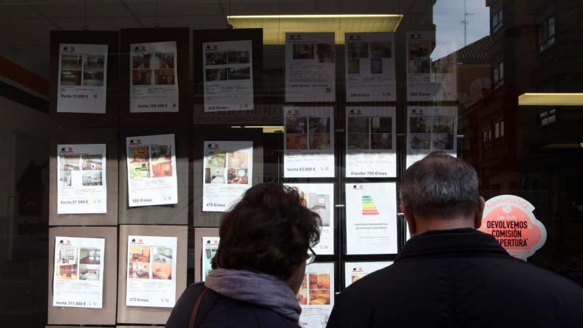 Una pareja mira los anuncios de una inmobiliaria en Valladolid-ICAL