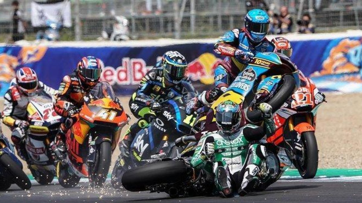 Àlex Márquez (Kalex), a la derecha, con casco azul, salta, vuela, por encima de la moto y el cuerpo del australiano Remy Gardner, sentado ya en la pista tras su caída, en la salida de hoy de Moto2, en Jerez.-ALEJANDRO CERESUELA