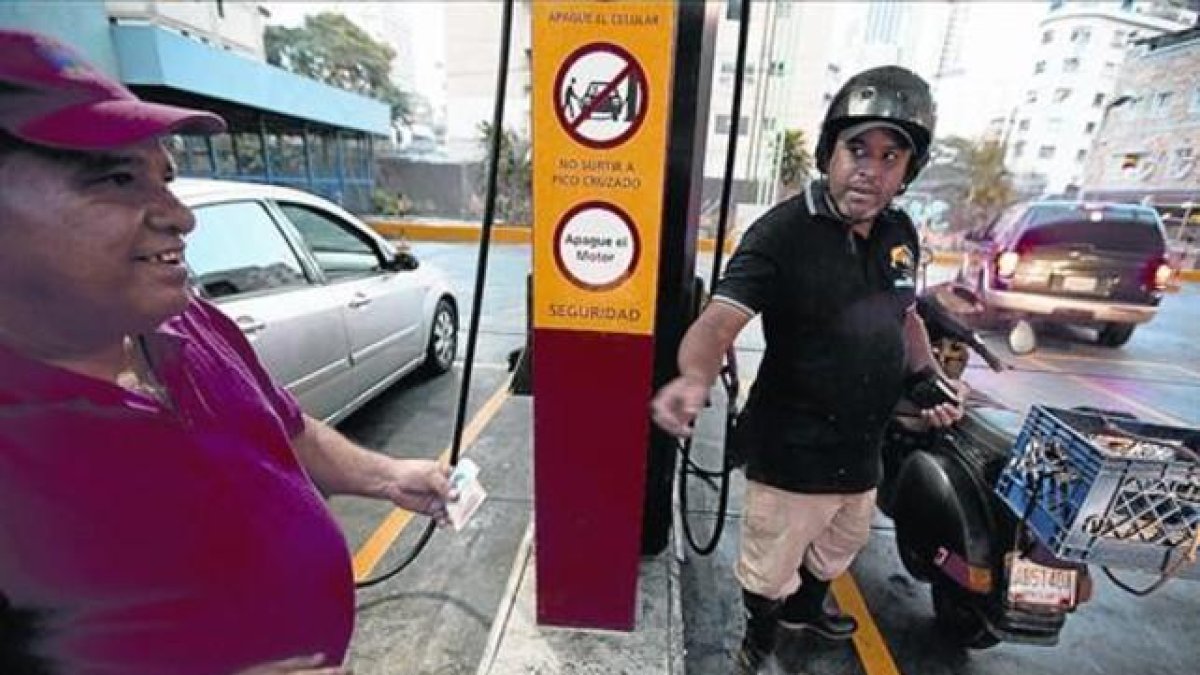 Un motorista paga, ayer, el combustible en una gasolinera de Caracas.-AFP / FERNANDO LLANO