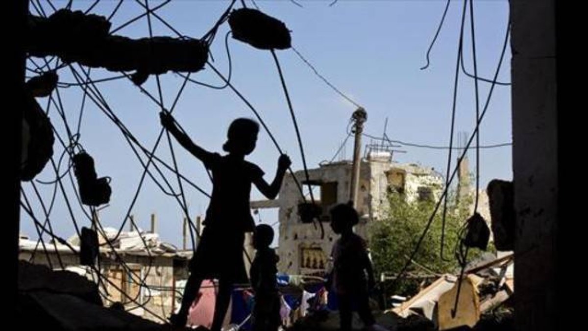Unos niños palestinos juegan en las ruinas de un edificio destruido.-Foto: AFP/ MOHAMMED ABED