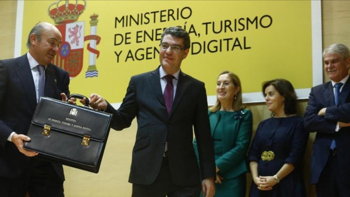 El ministro de Energía, Turismo y Agenda Digital, Álvaro Nadal, recibe la cartera ministerial de manos del titular de Economía, Luis de Guindos.-AGUSTIN CATALAN