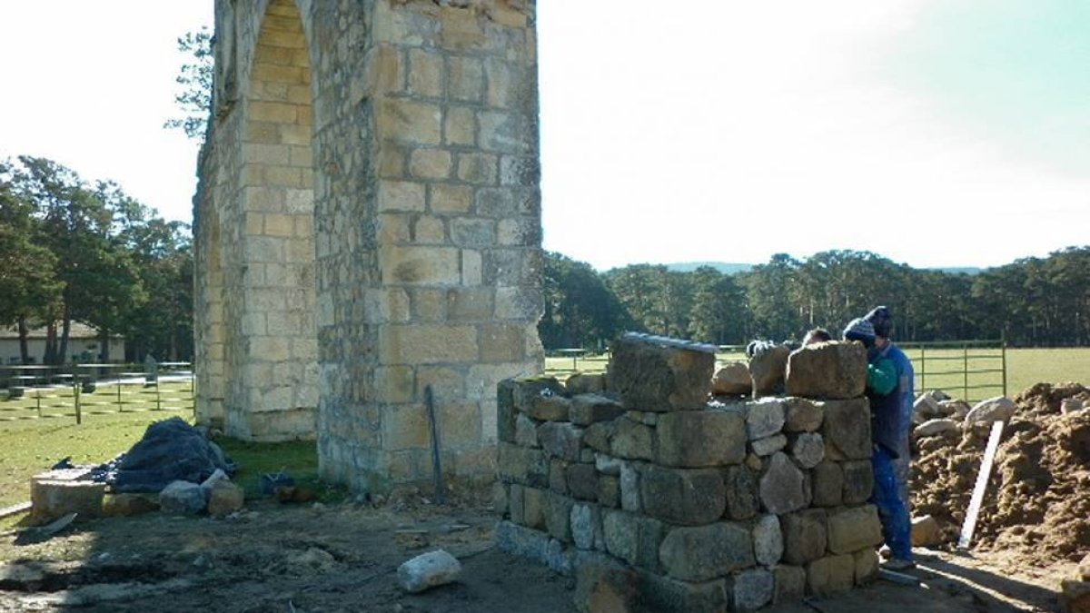 Operarios reconstruyendo la base del arco derruido.-