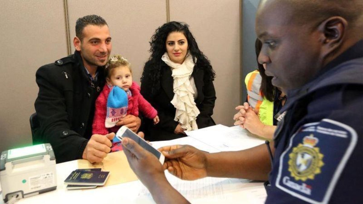 Una familia de refugiados sirios recién llegada al aeropuerto de Toronto (Canadá), en el 2015.-GETTY IMAGES / KENNETH ALLAN