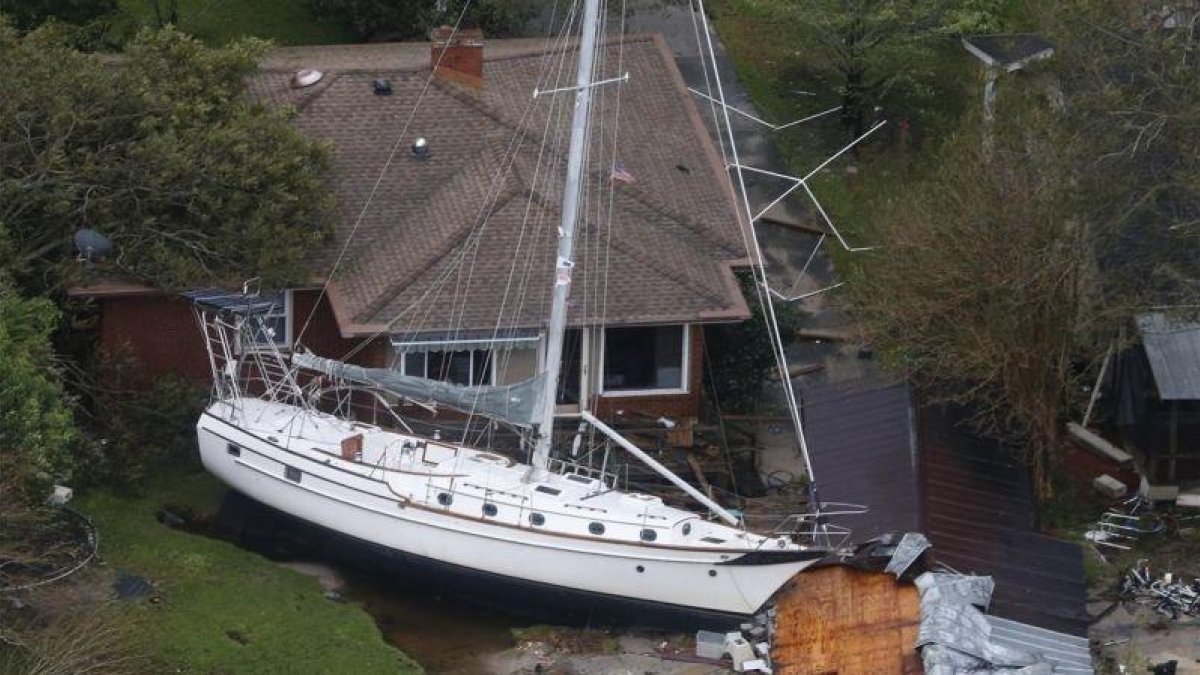 Una embarcación empotrada contra una casa a causa de los efectos del Florence a su paso por New Bern, en Carolina del Norte.-STEVE HELBER (AP)