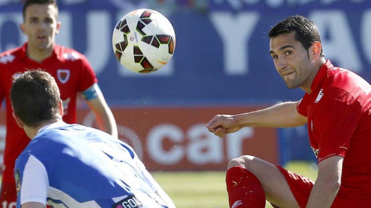 Antonio Tomás golpea el balón ante la presencia de un rival y de Julio Álvarez.-Área 11