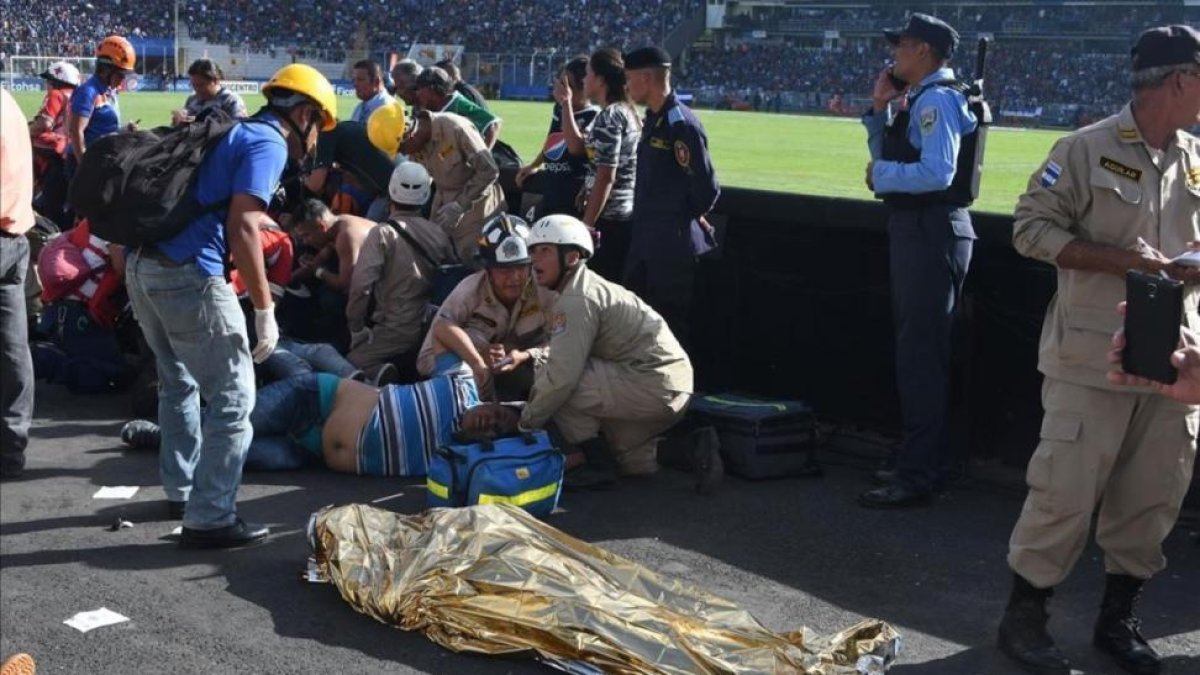 Las asistencias médicas atienden a varios heridos cerca de uno de los dos fallecidos dentro del estadio-AFP