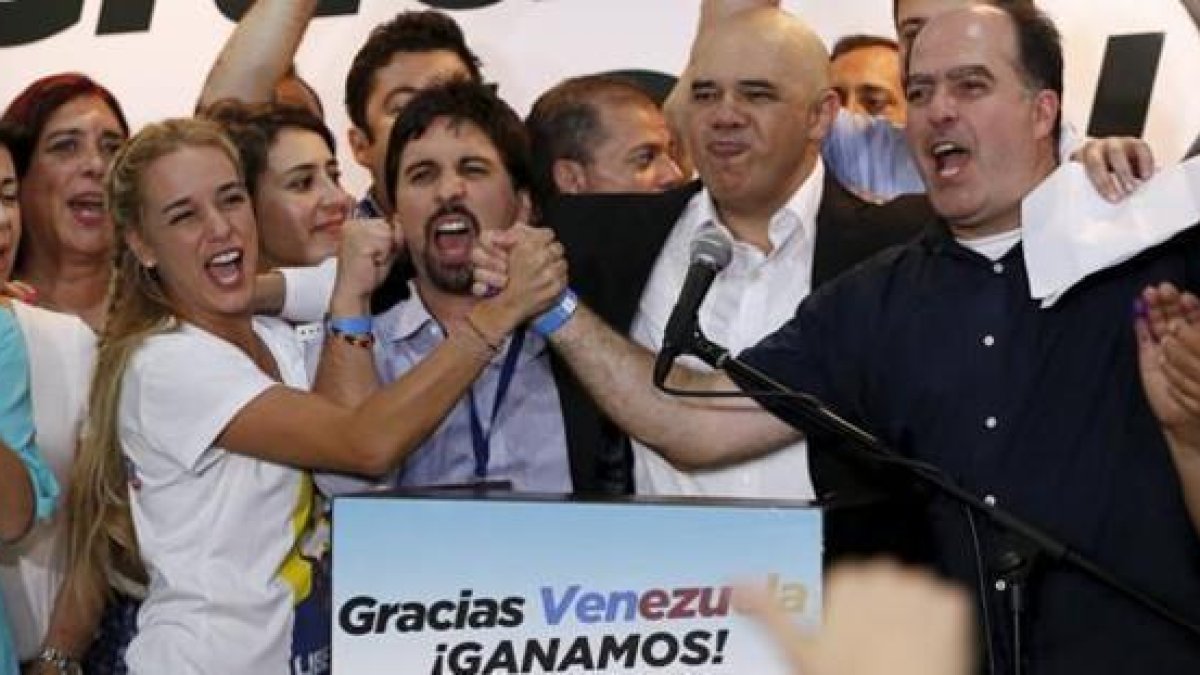 Lilian Tintori (izq), esposa del dirigente encarcelado Leopoldo López, celebra con otros representantes de la MUD la victoria electoral, en Caracas.-REUTERS / CARLOS GARCÍA RAWLINS