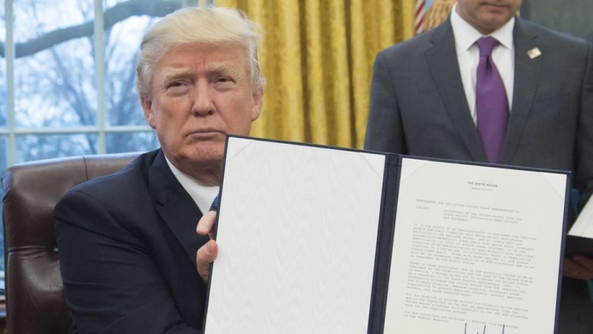 Trump muestra su firma sobe la orden de retirada del acuerdo de comercio Transpacífico.-SAUL LOEB / AFP