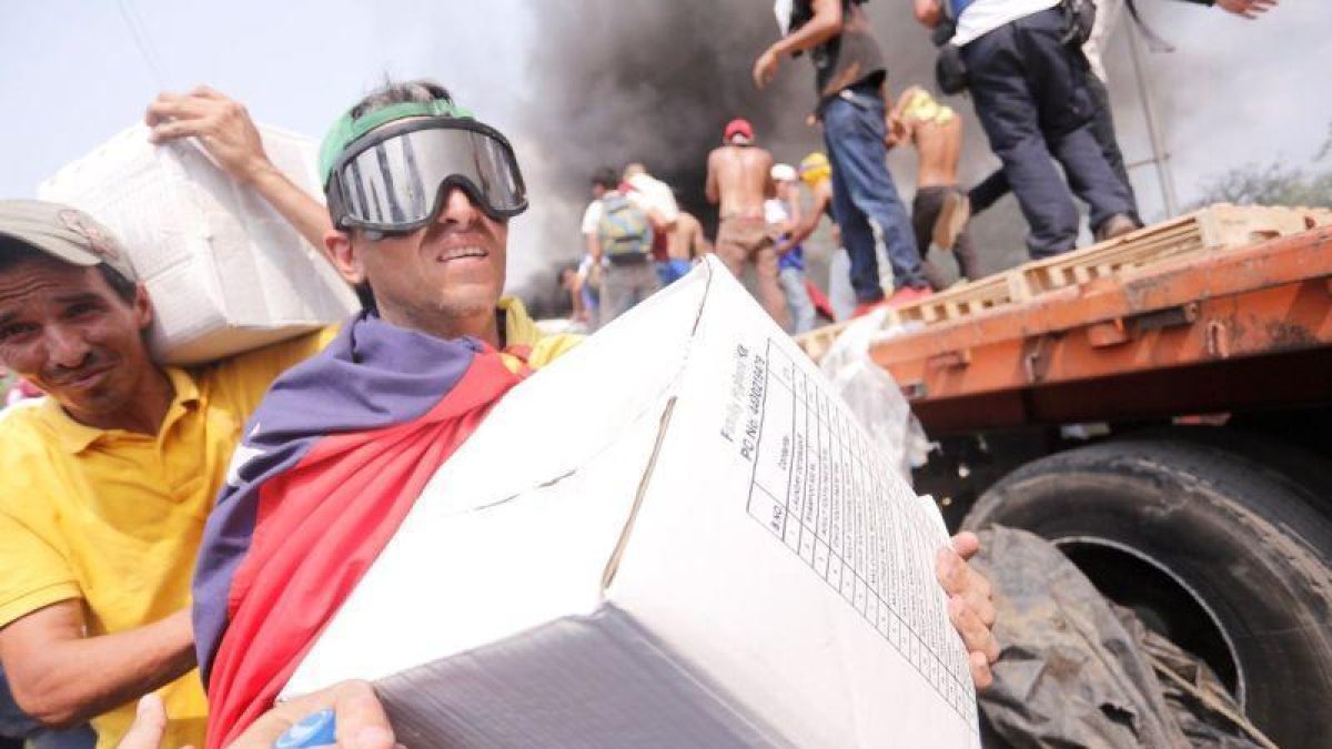 Venzolanos con cajas de ayuda humanitaria que entró por la fontera con Colombia.-EFE