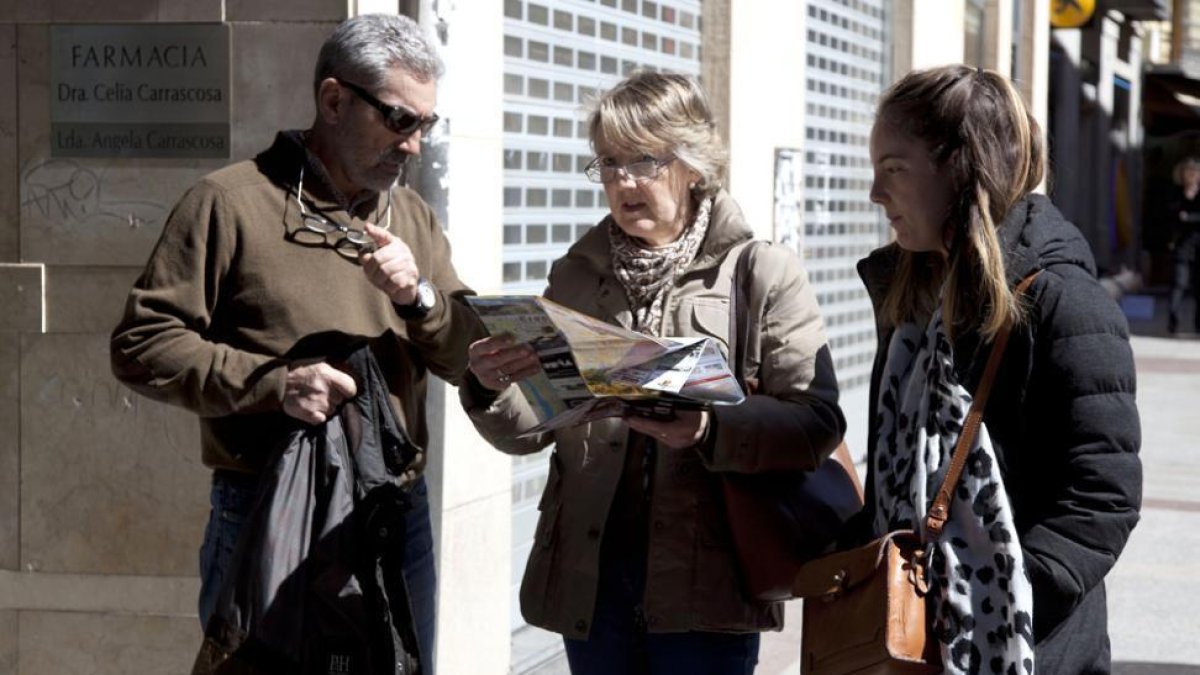 Tres personas consultan información turística en el centro de la capital.-DIEGO MAYOR