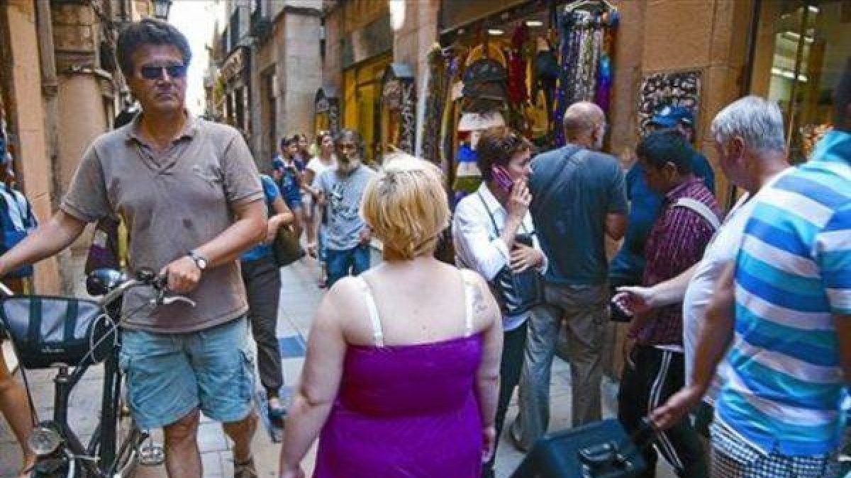 Paseantes y compradores, en una de las pequeñas y concurridas calles del Gòtic.-Foto: ARCHIVO / JOAN PUIG