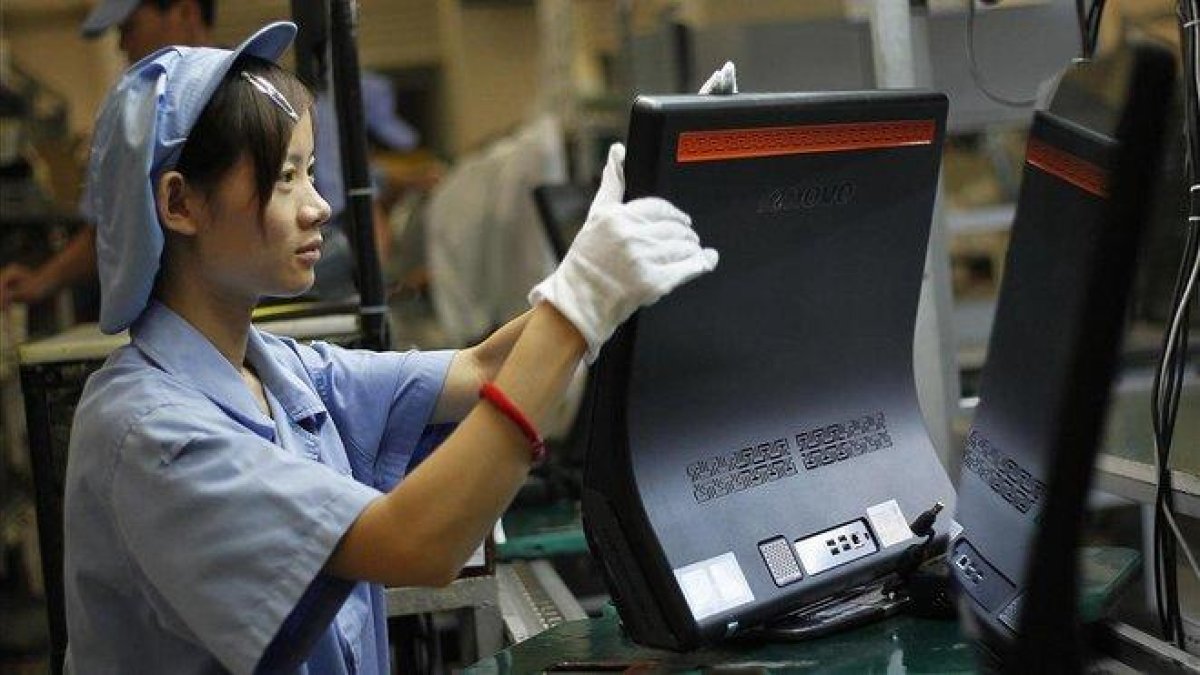 Una mujer trabaja en la línea de producción de Lenovo, en la planta que la empresa tiene en Shanghái.-EUGENE HOSHIKO (AP)