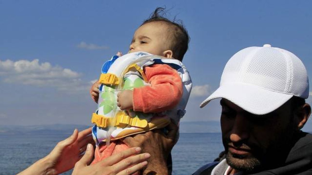 Un bebé llega a la isla griega de Mytilini tras salir de Turquía, este domingo.-Foto: EFE / ORESTIS PANAGIOTOU