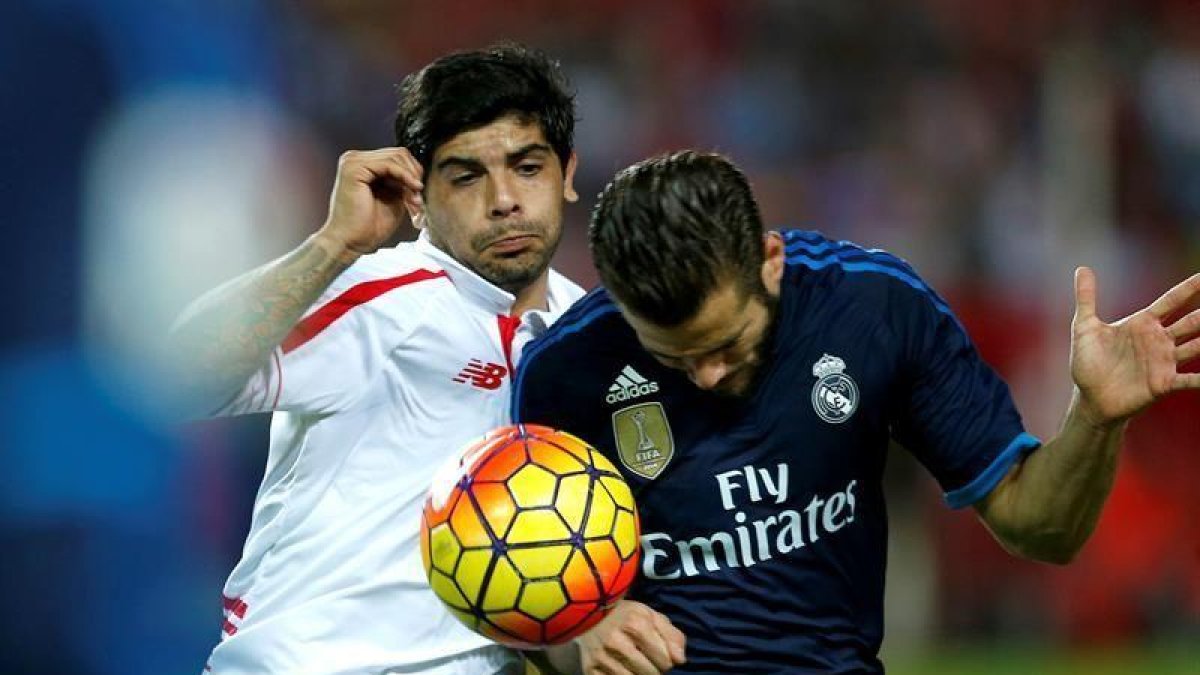 Éver Banega pelea un balón con Nacho.-EFE