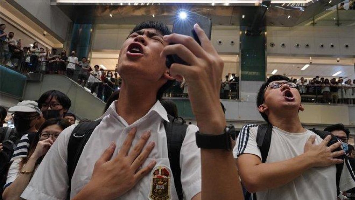 Unos jóvenes entonan el himno ’Gloria a Hong Kong’ en un centro comercial.-VICENT YU (AP)
