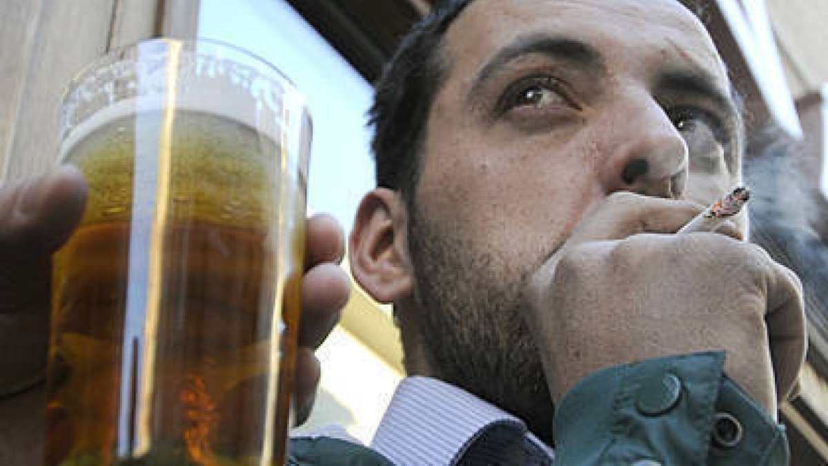 Un hombre fuma, ayer, en la puerta de un bar de Soria. / VALENTÍN GUISANDE-