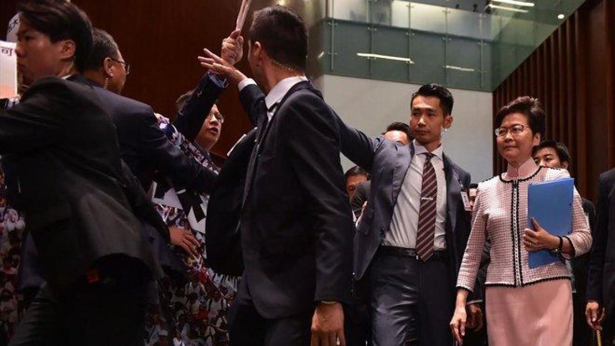 Diputados de la oposición increpan a la jefa del gobierno de Hong Kong.-AFP / ED JONES