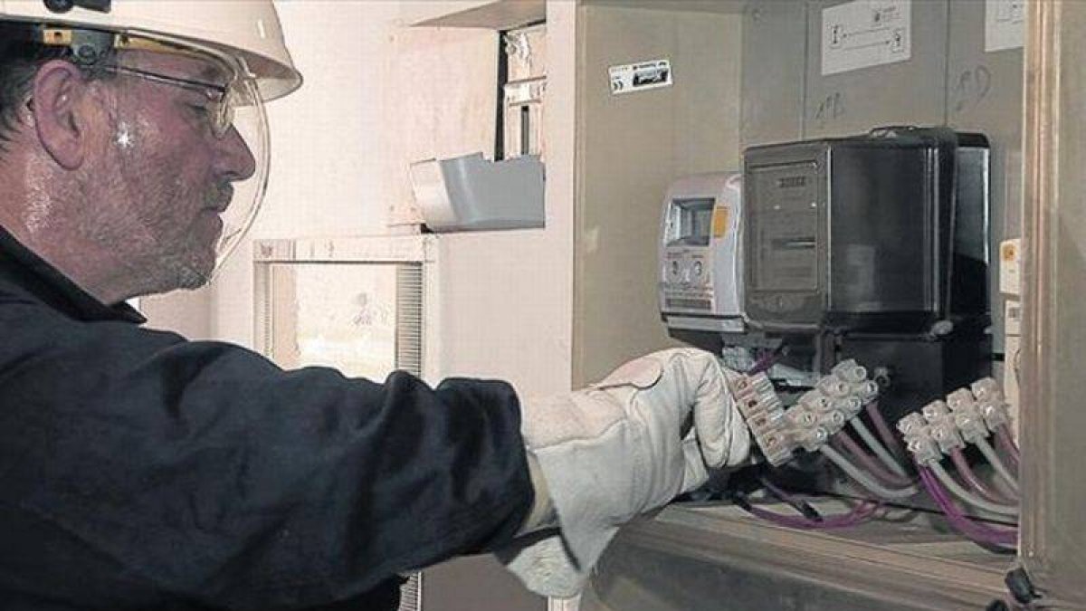 Un operario coloca contadores digitales para Endesa en un domicilio.-Foto: EL PERIÓDICO
