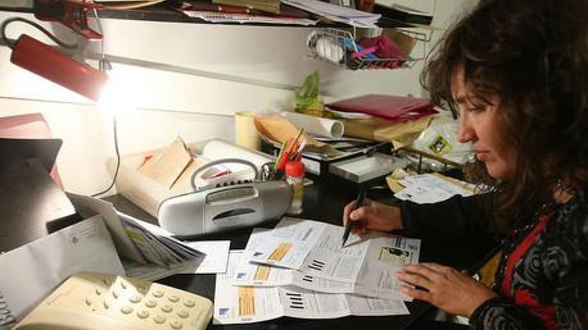 Una mujer consulta la factura de la luz.-ÁLVARO MONGE