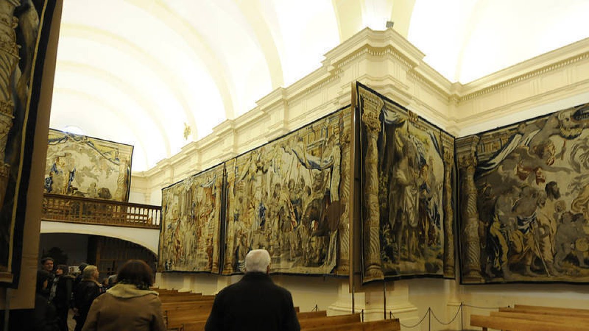 Visitantes ante los tapices del templo de San Millán. / VALENTÍN GUISANDE-