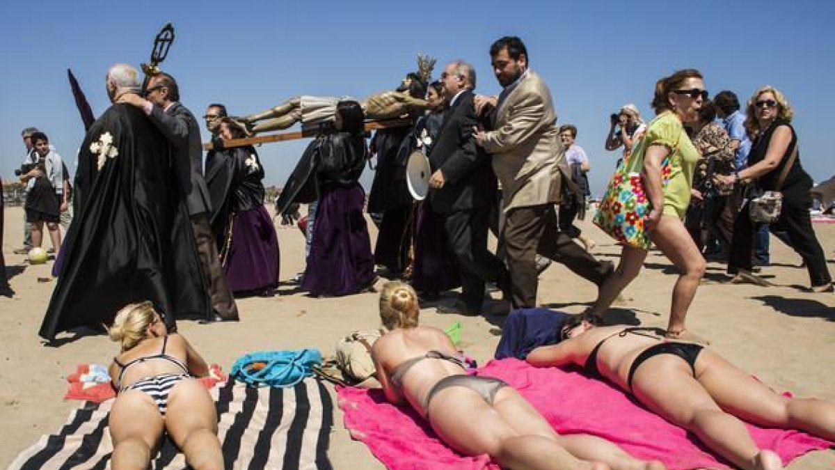Bañistas y cofrades, en la playa de la Malvarrosa de Valencia, en la Semana Santa del 2014.-MIGUEL LORENZO