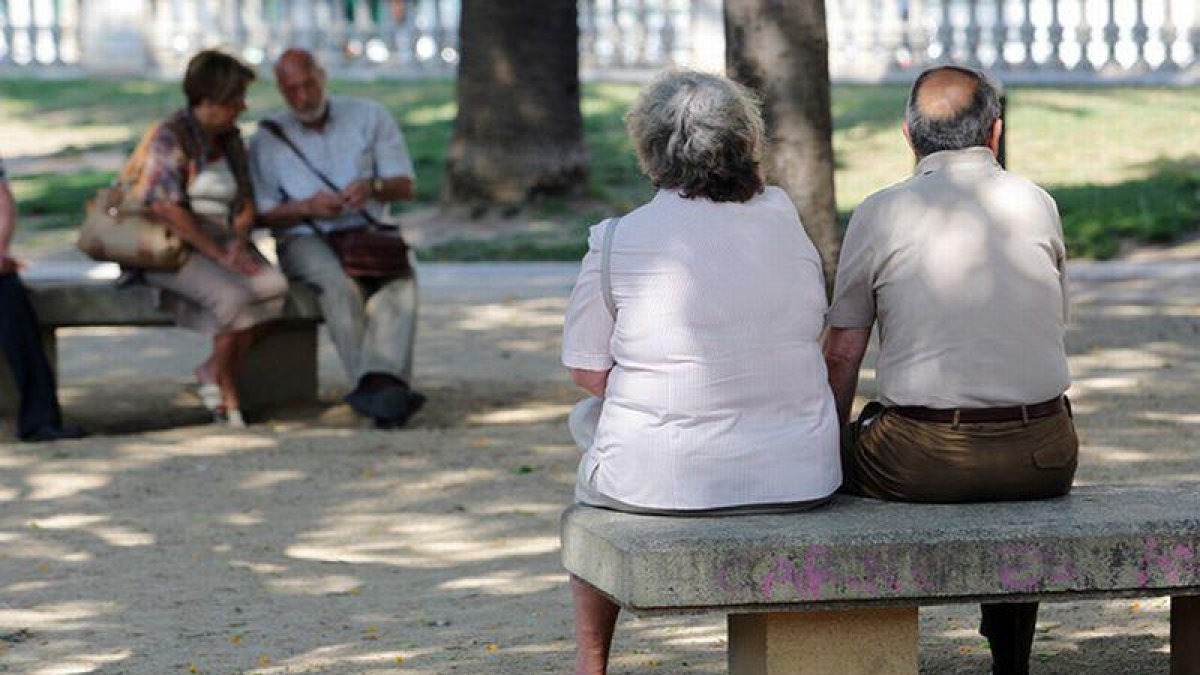 Personas mayores descansan en unos bancos de Barcelona.-RICARD CUGAT