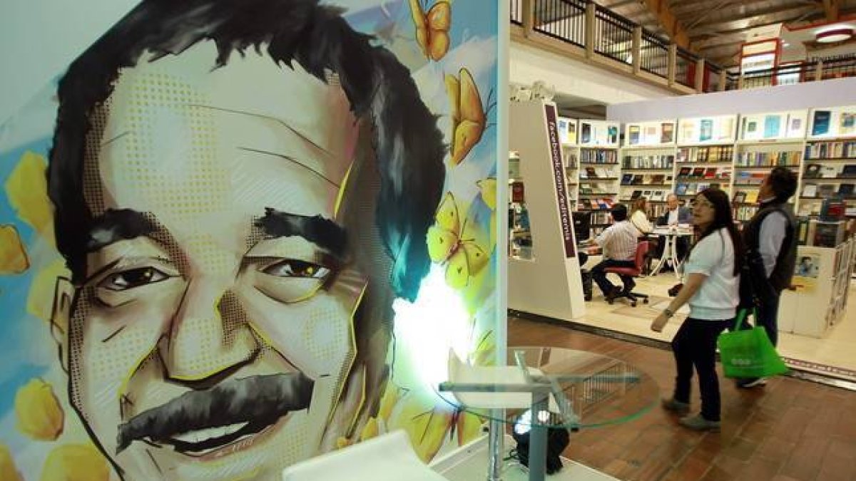 Una pareja pasa frente a una ilustración de Gabriel García Márquez en la Feria Internacional del Libro de Bogotá.-Foto:   EFE / MAURICIO DUEÑAS