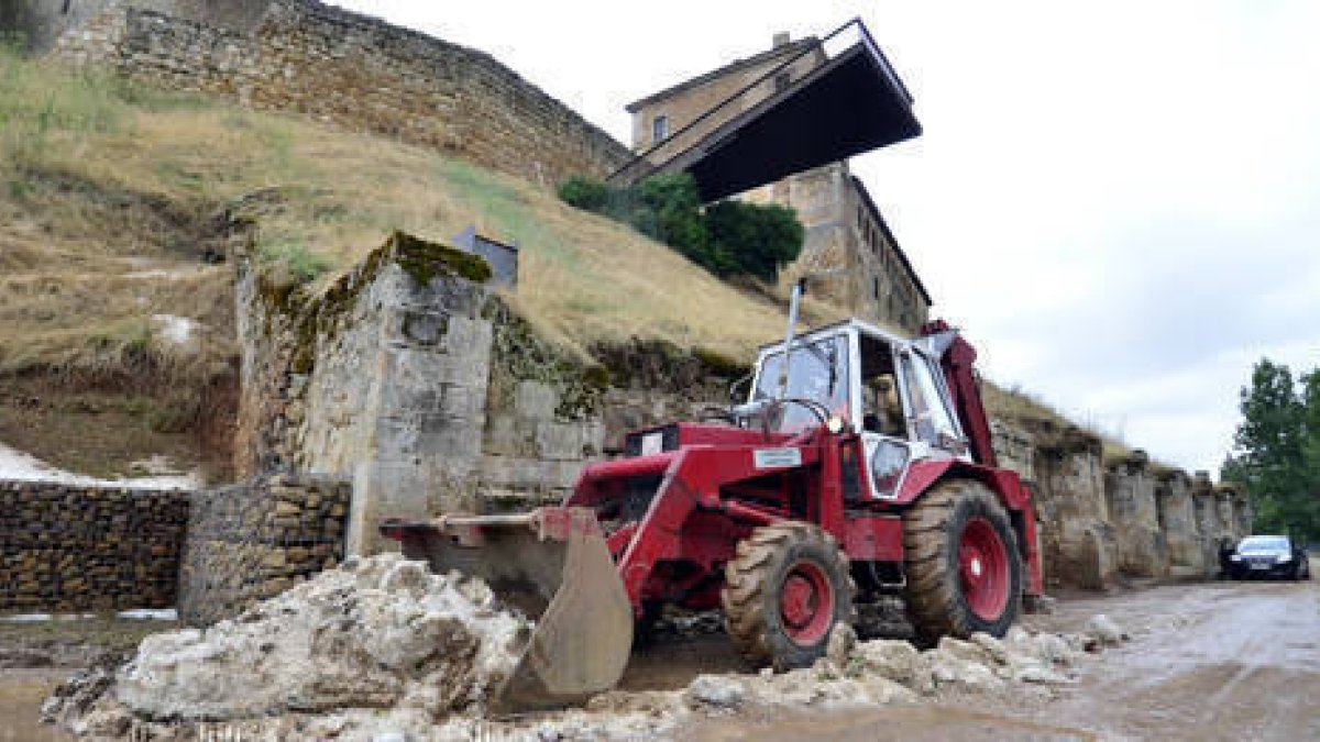 Una excavadora retiró ayer los desprendimientos de tierra en la parte baja del postigo de San Miguel. / ÁLVARO MARTÍNEZ-
