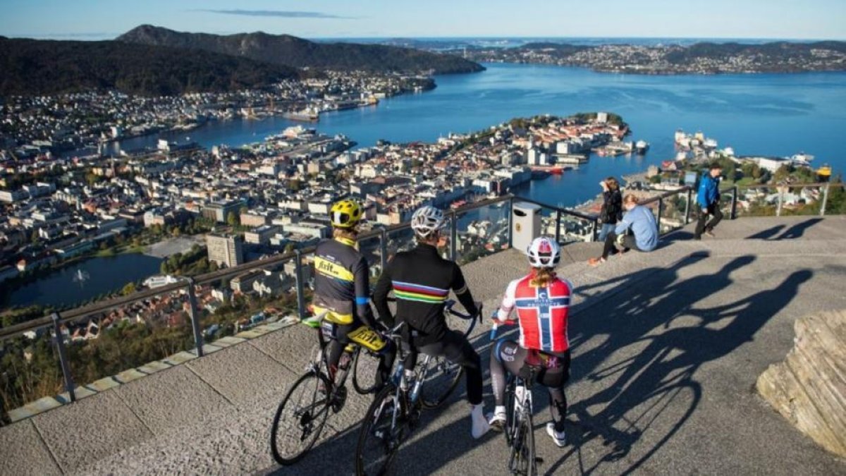 Tres ciclistas contemplan una panorámica de Bergen.-PERIODICO (BERGEN 2017)