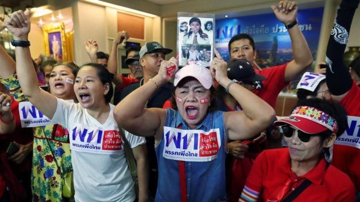 Seguidores del partido Pheu Thai, del exprimer ministro Thaksin Shinawatra, celebran los resultados no oficiales de las elecciones del 24 de marzo de 2019 en Bangkok.-ATHIT PERAWONGMETHA (REUTERS)