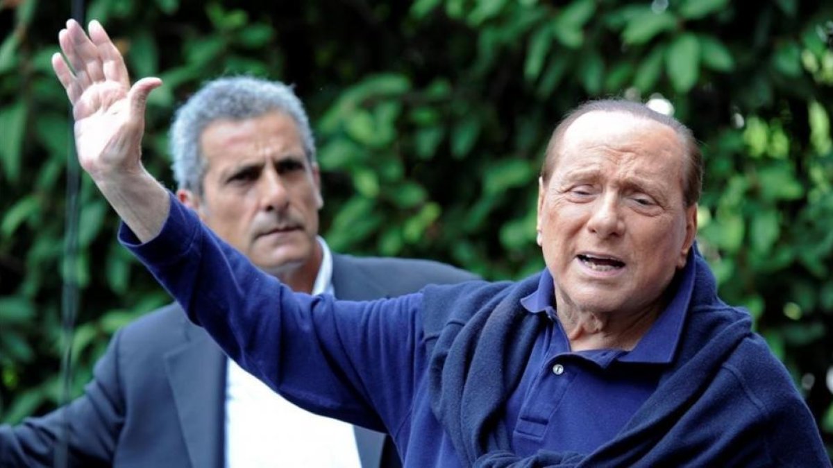 Silvio Berlusconi saluda a sus seguidores al salir del hospital.-STRINGER