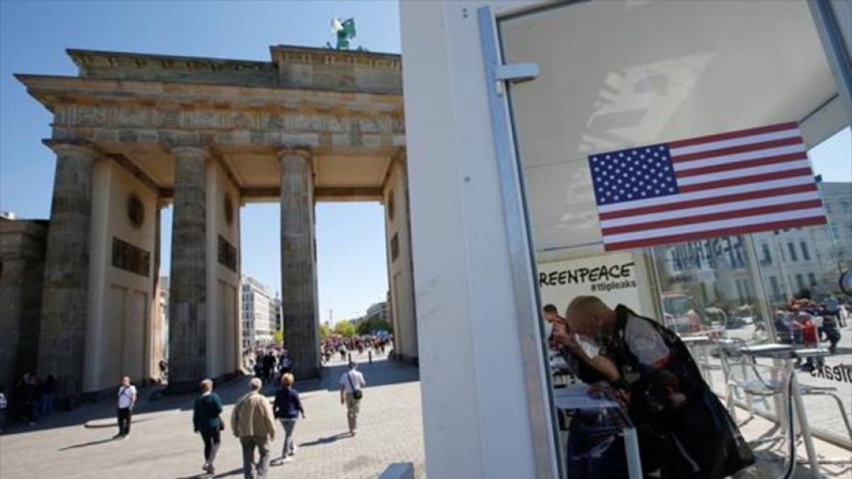 Ciudadanos consultan datos del TTIP, en una instalación de Greenpeace ante la puerta de Brandeburgo de Berlín, ayer.-REUTERS / FABRIZIO BENSCH