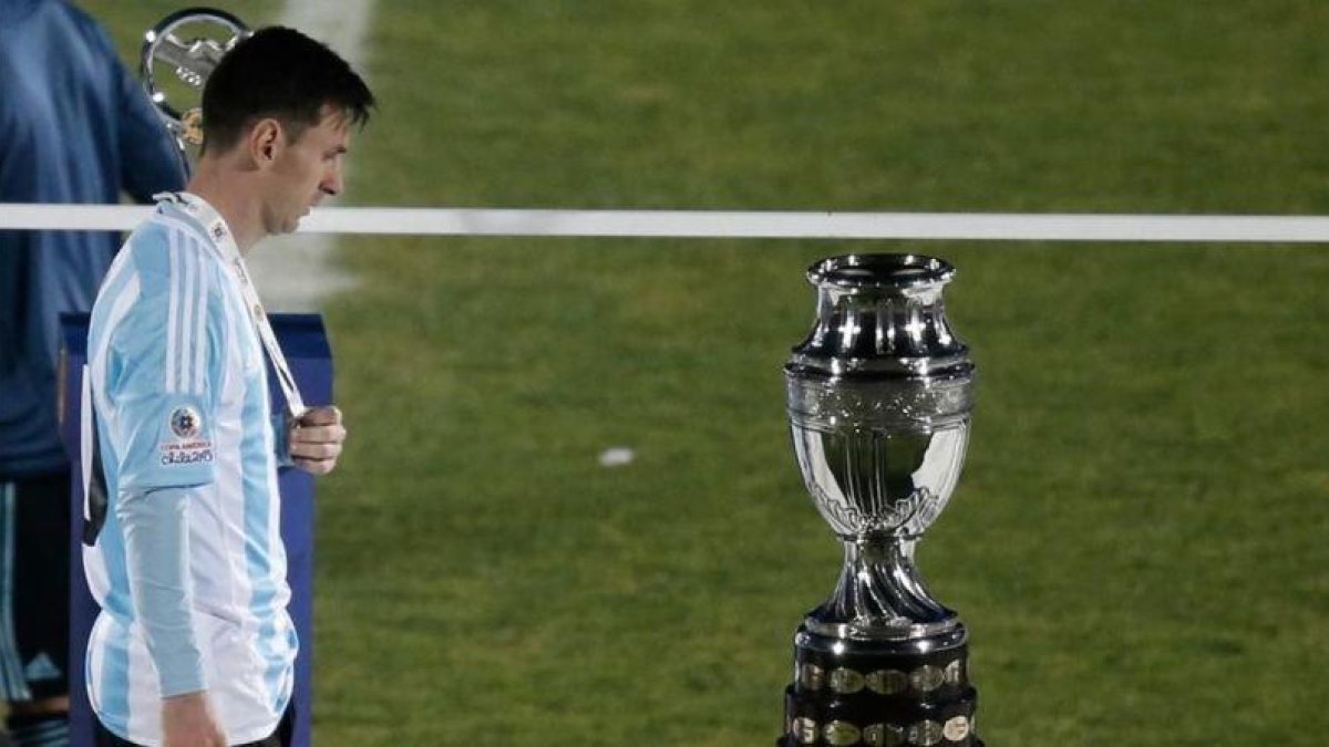 El delantero argentino Leo Messi mira cabizbajo la Copa América tras perder la final ante Chile en los penaltis.-SILVIA IZQUIERDO / AP