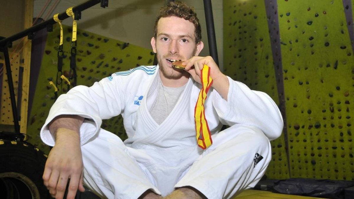 Alexis Rosa posa con su medalla de oro en las instalaciones de La Nave Deporte y Ocio, una de las pocas empresas que apoyan al deportista.-VALENTÍN GUISANDE