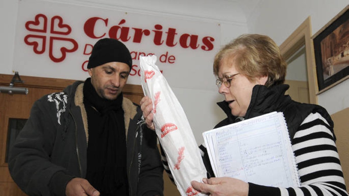 Un hombre recibe alimentos en Cáritas. / FERNANDO SANTIAGO-