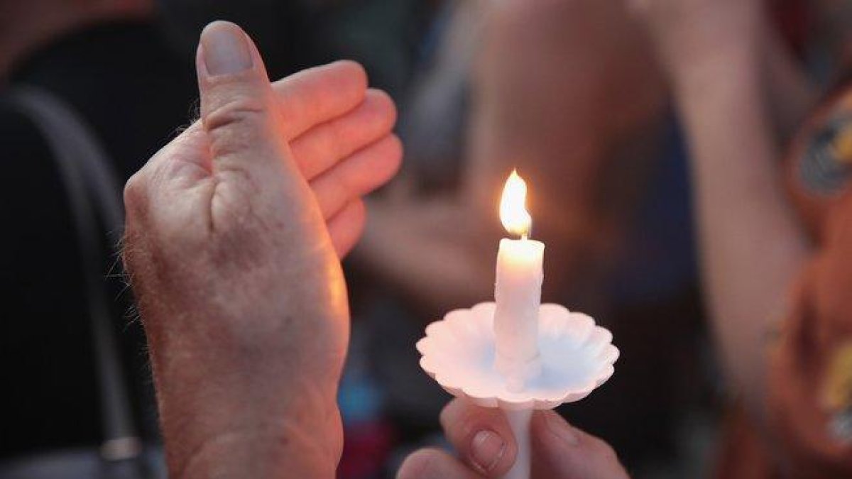 Un hombre enciende una vela por las víctimas del tiroteo en Ohio.-GETTY IMAGES NORTH AMERICA