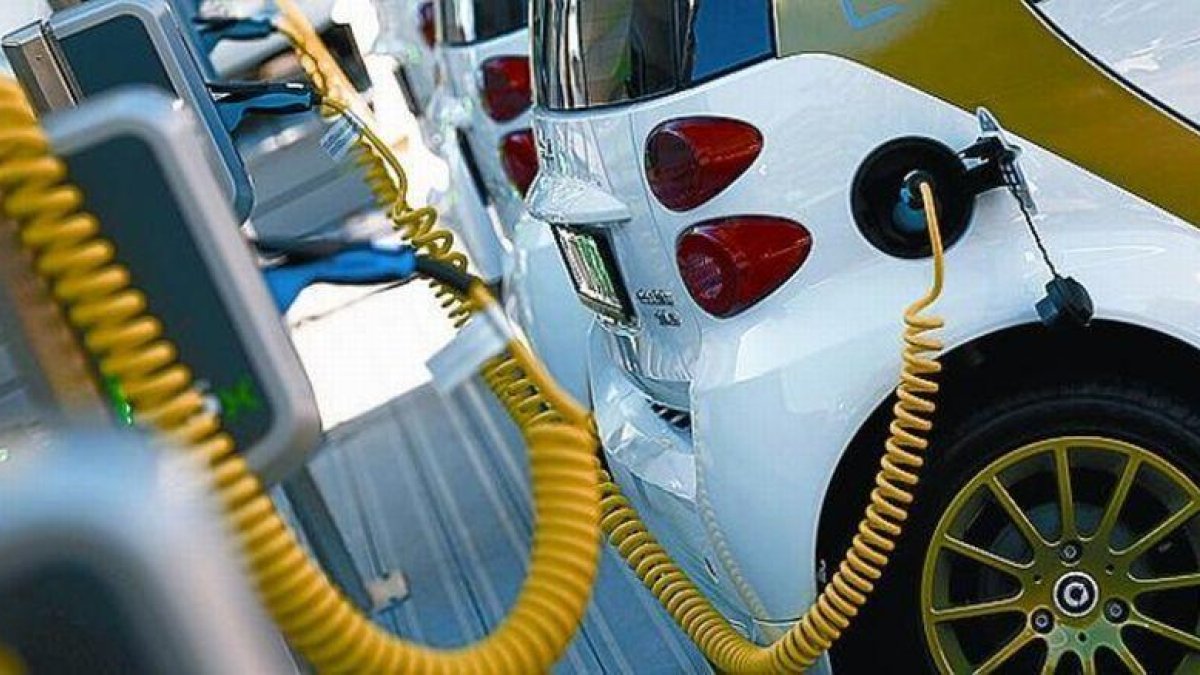 Coche eléctrico enchufado a un punto de carga.-REUTERS / KAI PFAFFENBACH