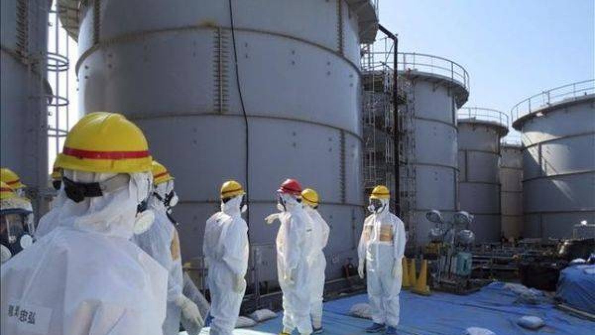 Operarios ante los tanques de agua radiactiva en Fukushima.-Foto: EFE