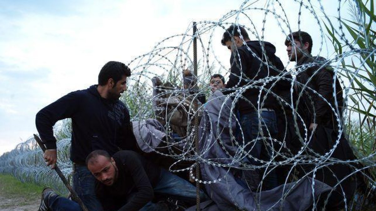 Refugiados sirios entran en Hungría por debajo de la valla de la frontera húngara-AGENCIAS