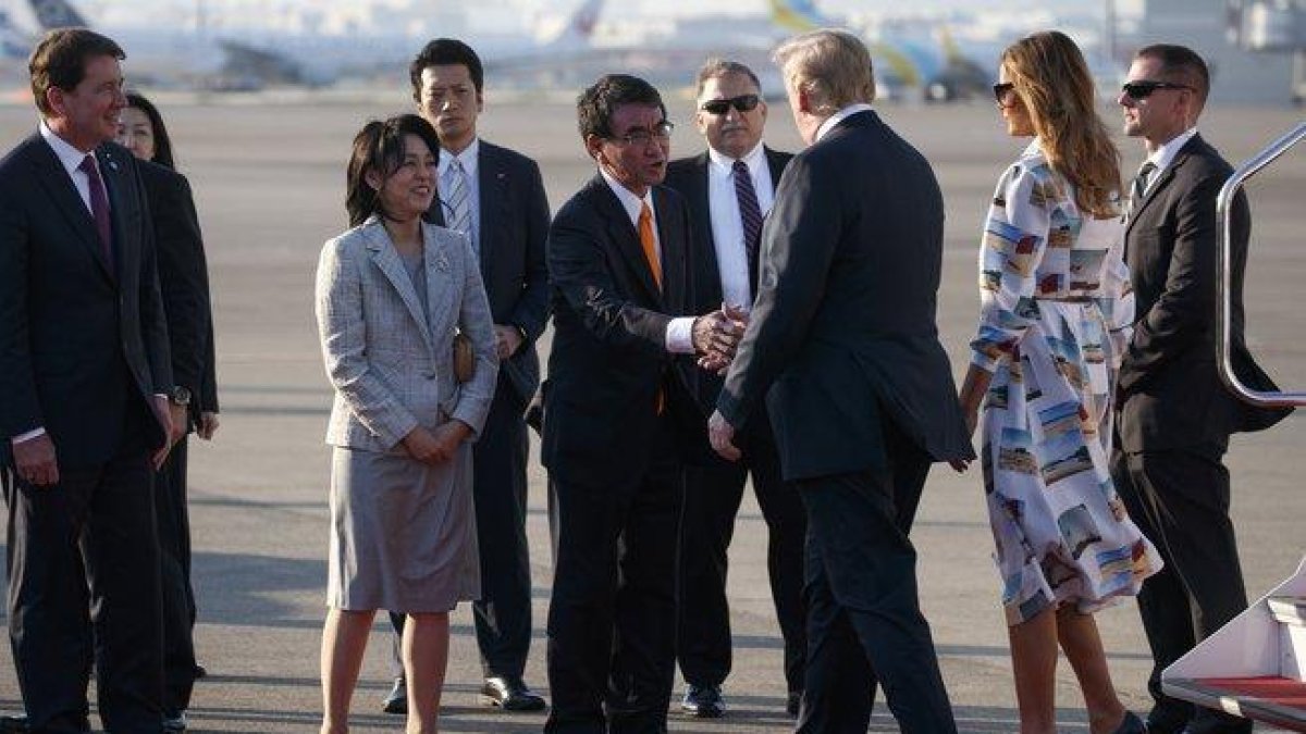 El presidente de EEUU, Donald Trump, y su esposa Melania saludan al ministro de Asuntos Exteriores japonés, Taro Kono, y su esposa Kaori, a su llegada al Aeropuerto de Haneda, en la prefectura de Tokio.-AP / EVAN VUCCI (AP)