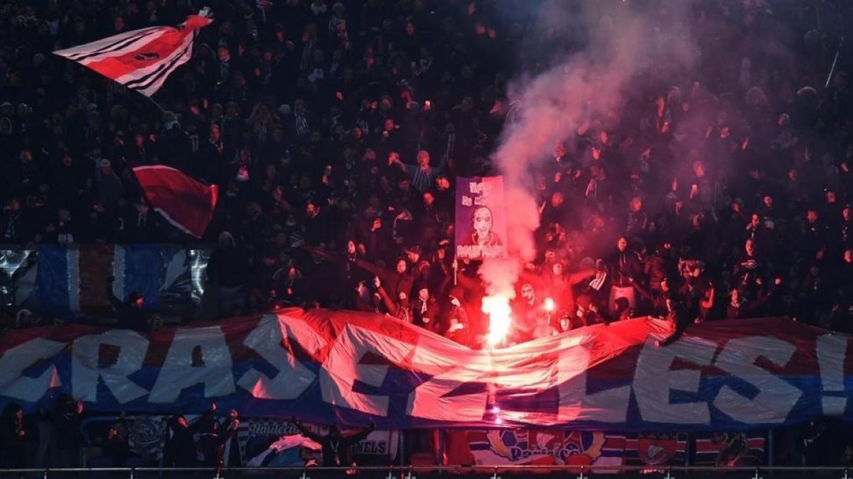Aficionados del París SG encienden bengalas durante el partido de Copa ante el Olympique.-/ AFP / CHRISTOPHE SIMON