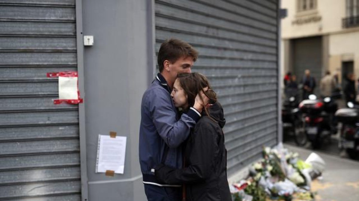 Una pareja se abraza frente a los restaurantes Le Carillon y Le Petit Cambodge, este sábado.-AP / JEROME DELAY