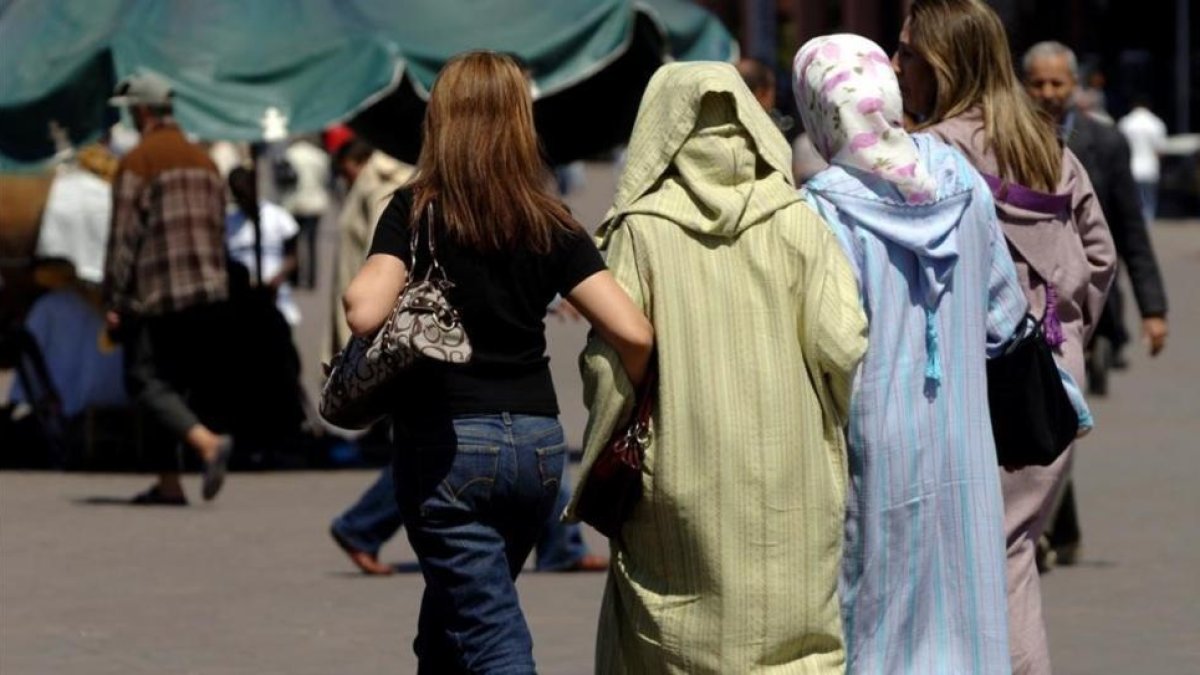 Mujeres vestidas al uso occidental junto a otras con vestimentas tradicionales, en la plaza Jemaa El Fna, en Marraquech, en una imagen de archivo.-XAVIER JUBIERRE