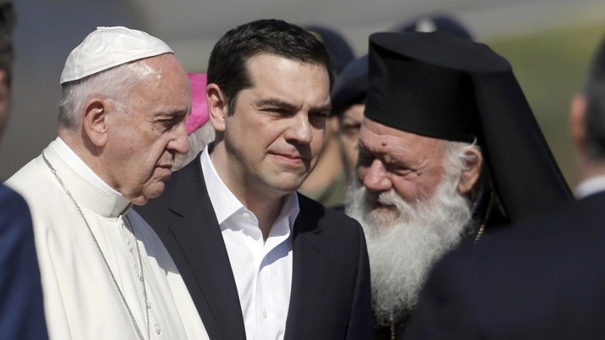 El Papa, recibido por el primer ministro griego, Alexis Tsipras, y el patriarca de la iglesia ortodoxa griega, Bartolomé I, en Lesbos.-REUTERS